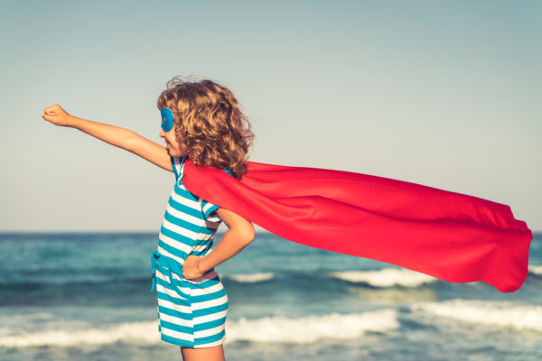 Girl with a red cape blowing behind her